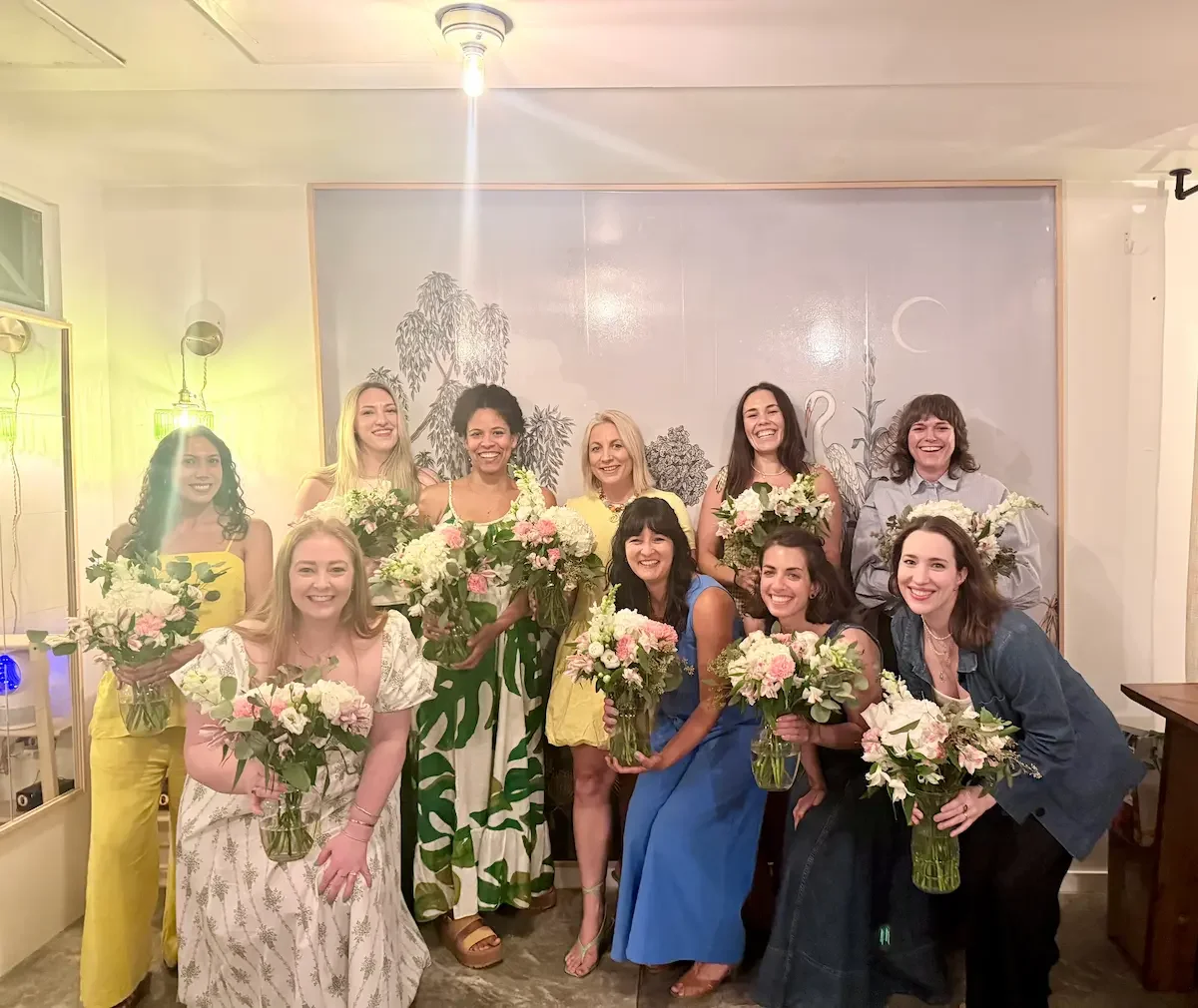 A group of guests holding handmade bouquets after a guided floral workshop at Bat Haus, an event space in Williamsburg, Brooklyn.