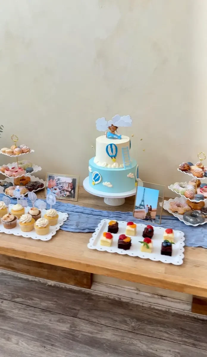 A blue baby shower cake and dessert table spread at Bat Haus, a BYO baby shower venue in Williamsburg, Brooklyn.