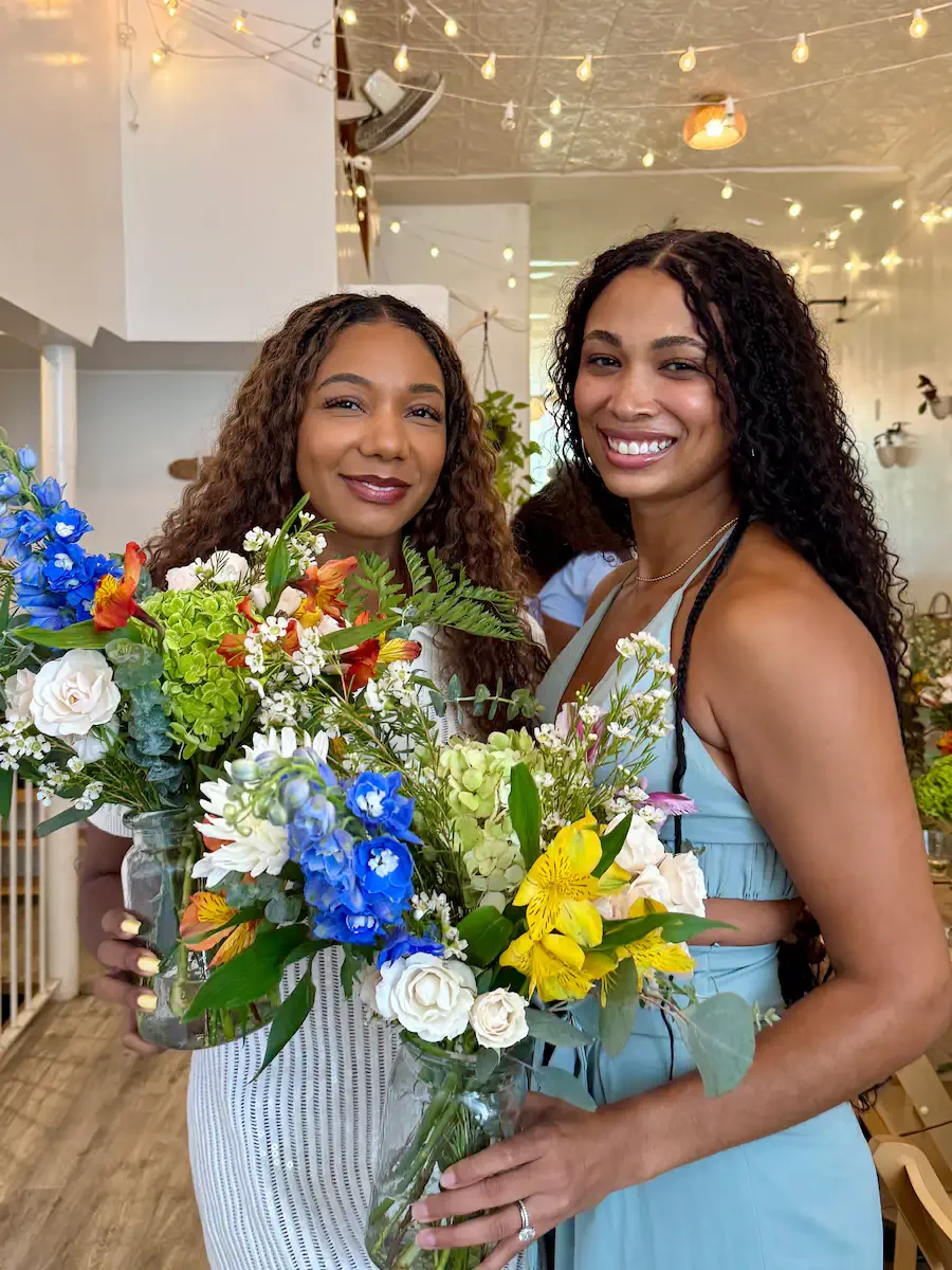 Two friends holding handmade bouquets at a bridal shower floral workshop at Bat Haus in Brooklyn.