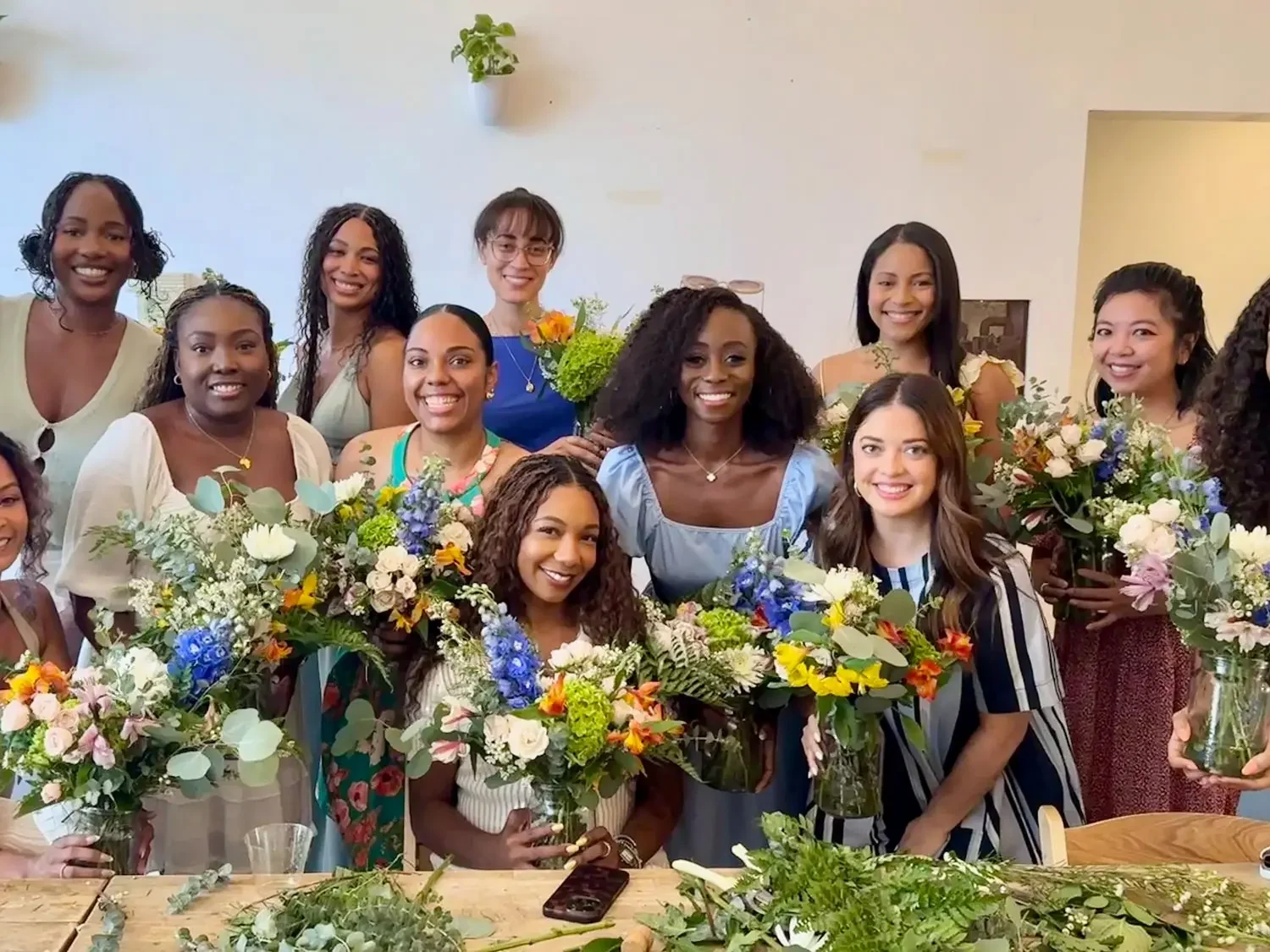 Group of guests holding handmade bouquets after a guided floral arranging workshop at Bat Haus event space in Williamsburg, Brooklyn.