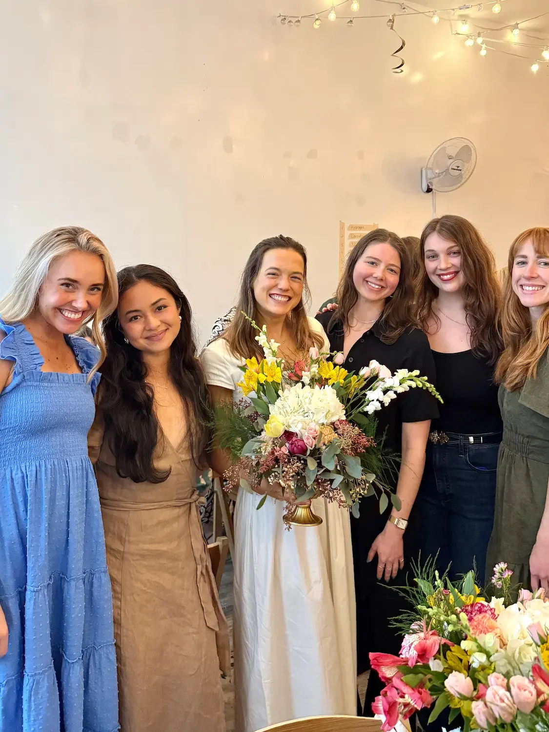 A group of friends holding handmade bouquets at a bridal shower floral workshop at Bat Haus in Brooklyn.