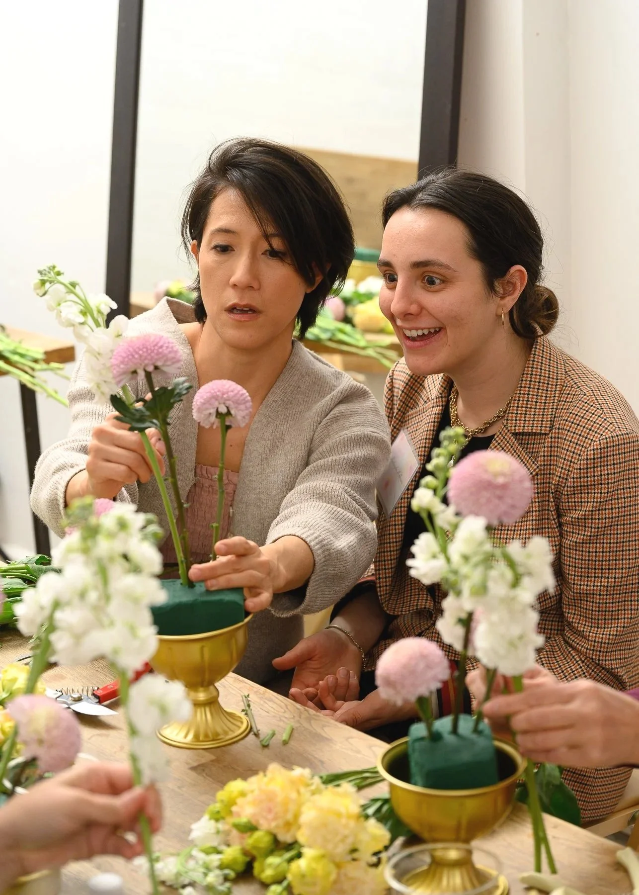 Guided floral design instruction during a floral workshop experience at Bat Haus in Brooklyn, featuring hands-on arrangement and personalized teaching.