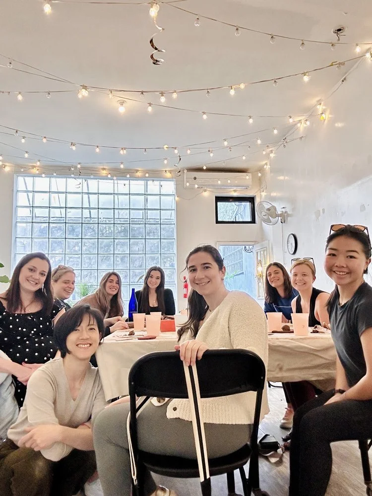 A group celebrating around the table at a birthday pottery class at Bat Haus in Williamsburg, Brooklyn.