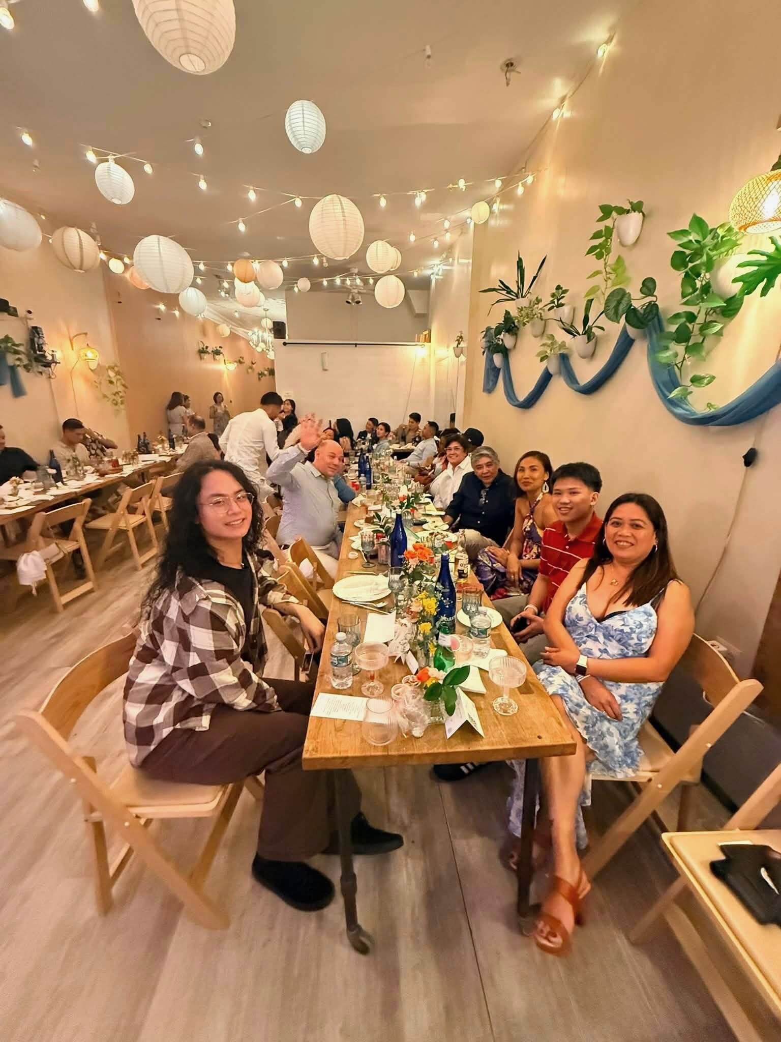 Wedding reception for 50 guests at long wooden banquet tables under paper lanterns and string lights at Bat Haus in Williamsburg, Brooklyn