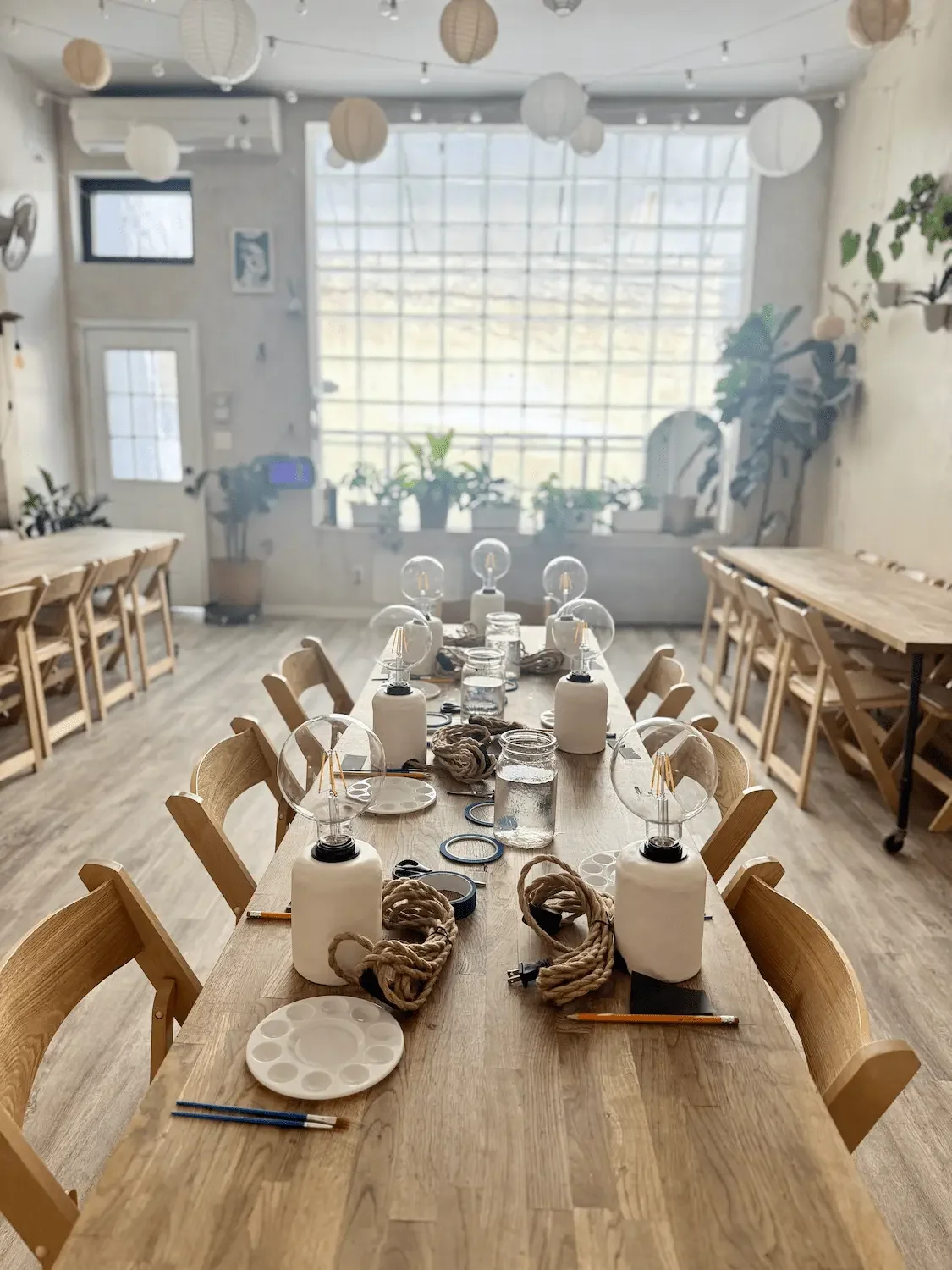 A long table set with materials for a weekday workshop in the light-filled Bat Haus studio in Williamsburg, Brooklyn.