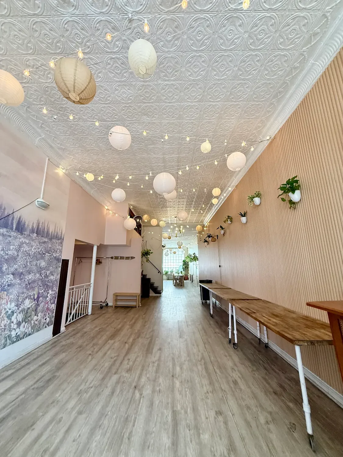 Long first-floor main space at Bat Haus in Williamsburg, Brooklyn, with tin ceiling, string lights and buffet tables