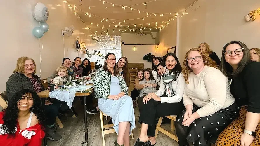 baby shower venue brooklyn at bat haus group of guests celebrating together in warm string light filled studio