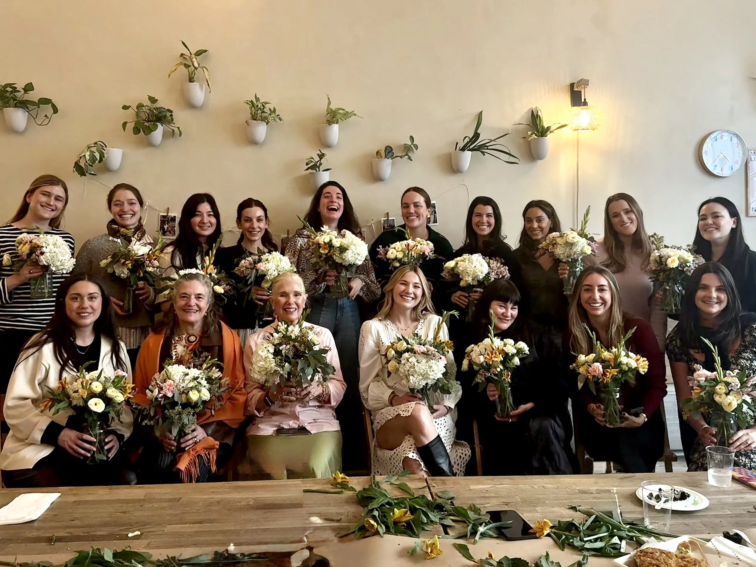bridal floral workshop brooklyn maiya bridal shower celebration with guests holding their flower arrangements at bat haus