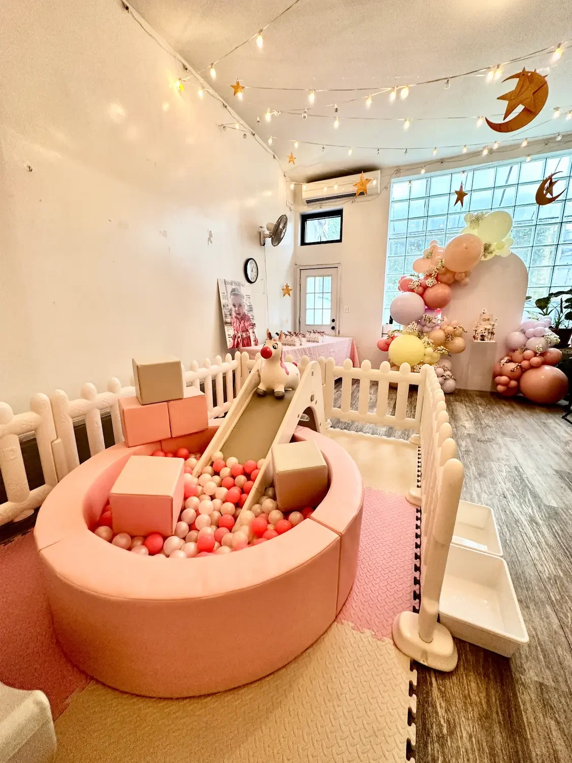 A fenced soft-play area with a ball pit and slide set up for a toddler birthday party at Bat Haus in Williamsburg, Brooklyn.