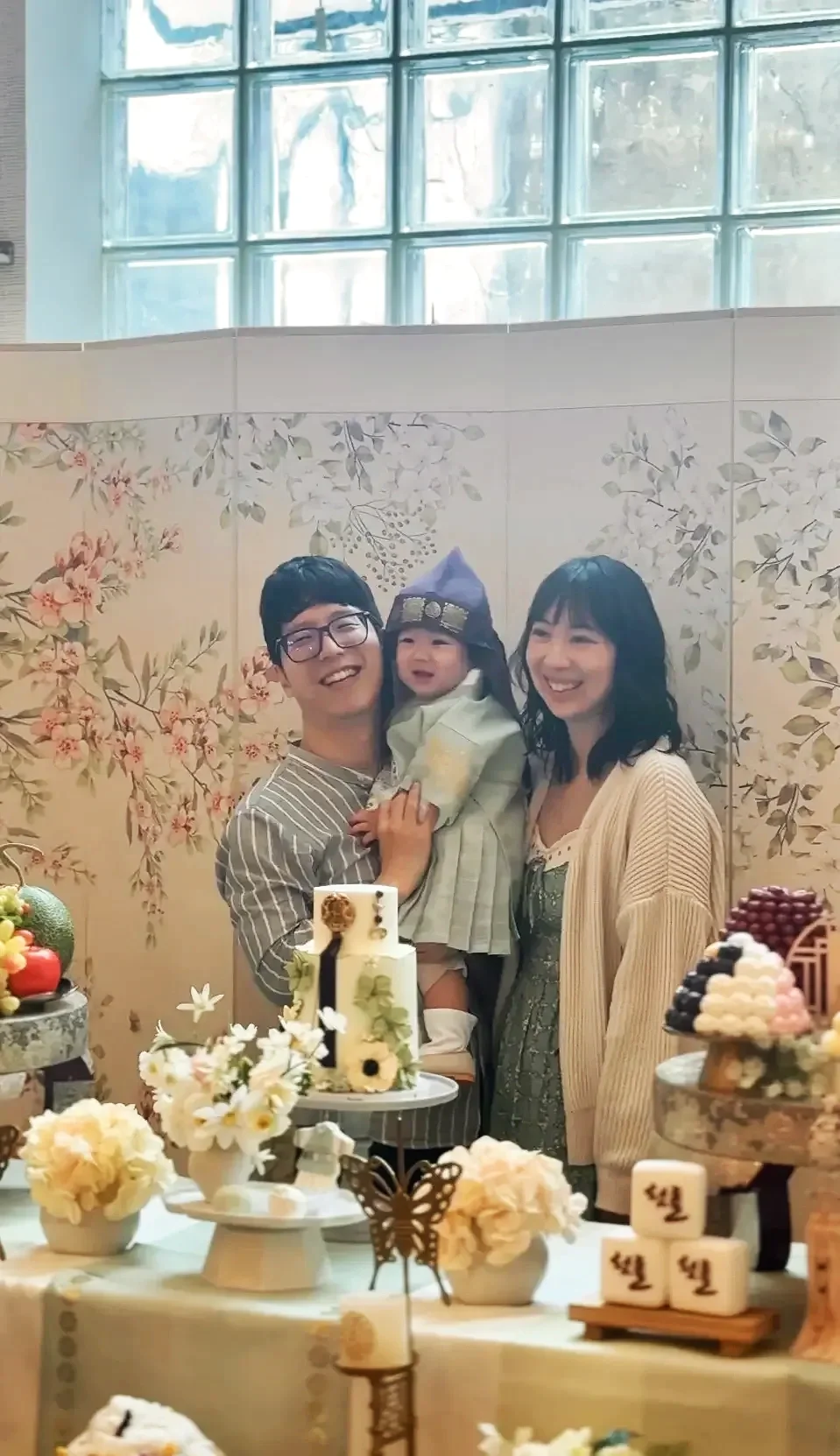 Parents and their child in hanbok at a Korean Doljanchi first-birthday celebration at Bat Haus in Williamsburg, Brooklyn.