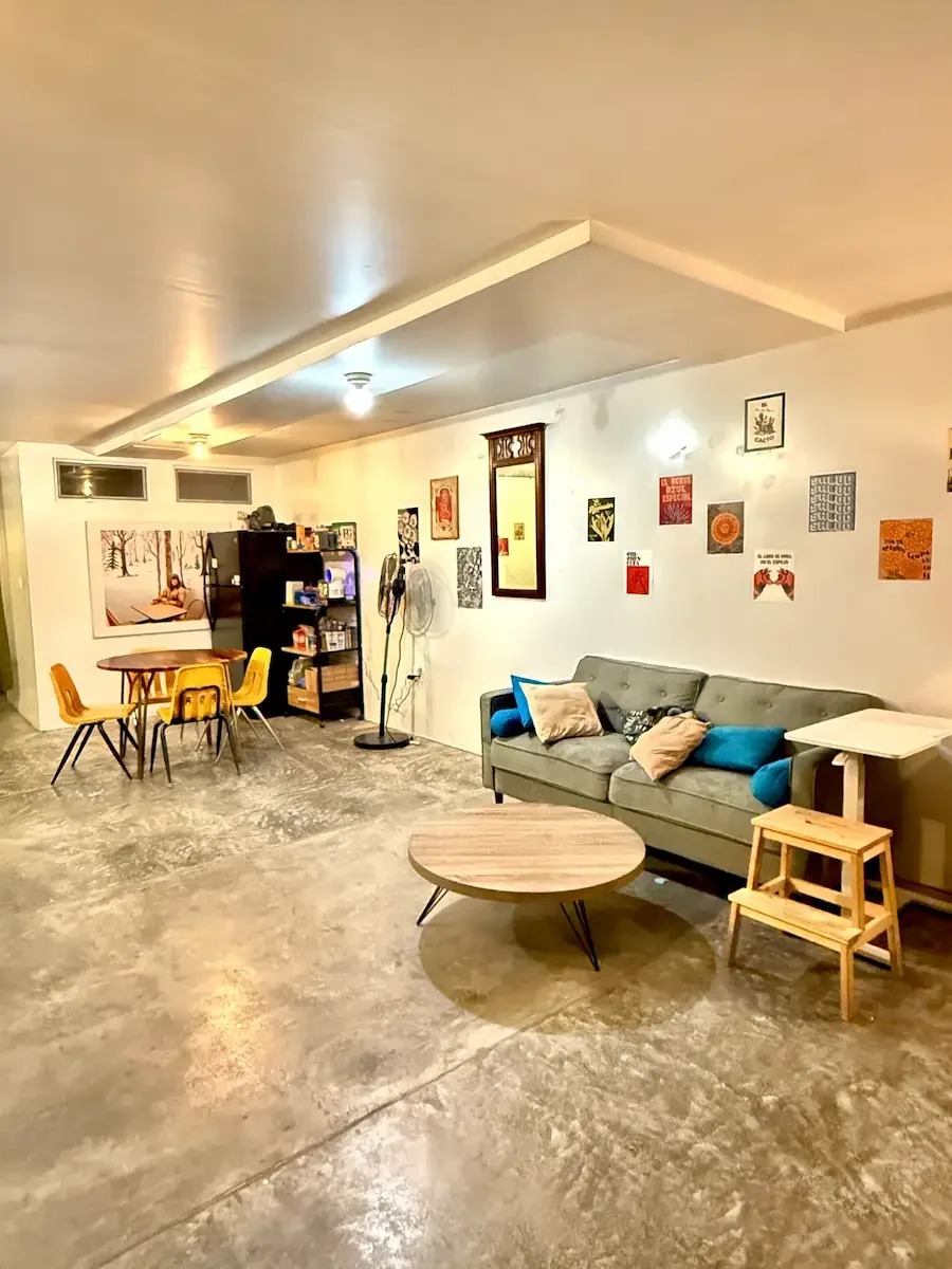 Private downstairs lounge area at Bat Haus Brooklyn with sofa seating, small tables, and open floor space, ideal for bridal suite, getting ready room, or quiet retreat during events.