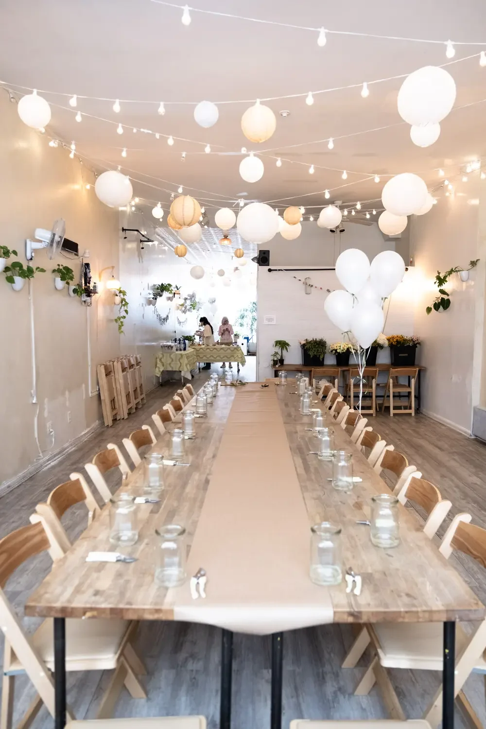 Main event room at Bat Haus Brooklyn from back angle with long table, string lights, and cozy setup for intimate events and celebrations