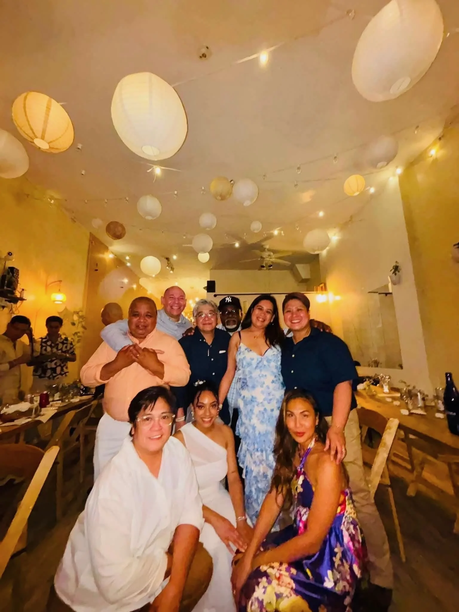 Family and friends gathered around the bride during an evening wedding reception at Bat Haus, a small wedding venue in Williamsburg, Brooklyn