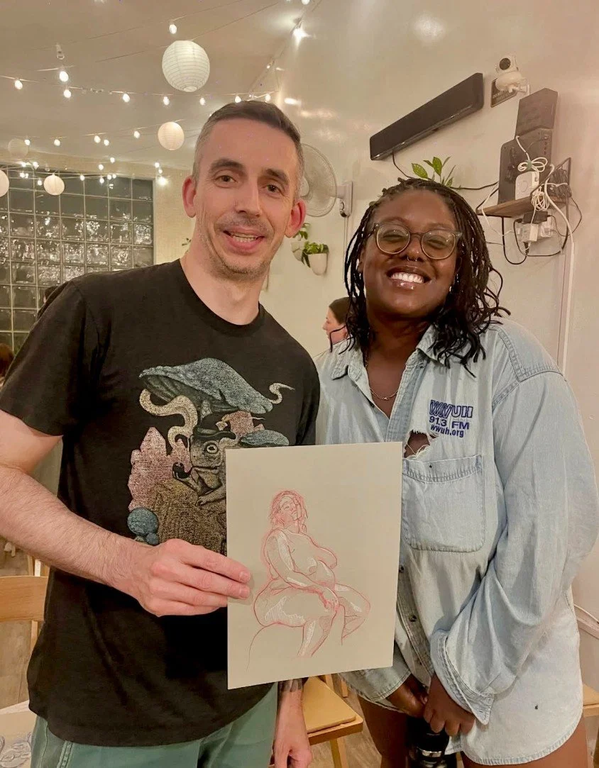 Two artists at Drink n Draw Brooklyn holding up their finished figure drawings during a relaxed community art night and weekly drawing class at Bat Haus