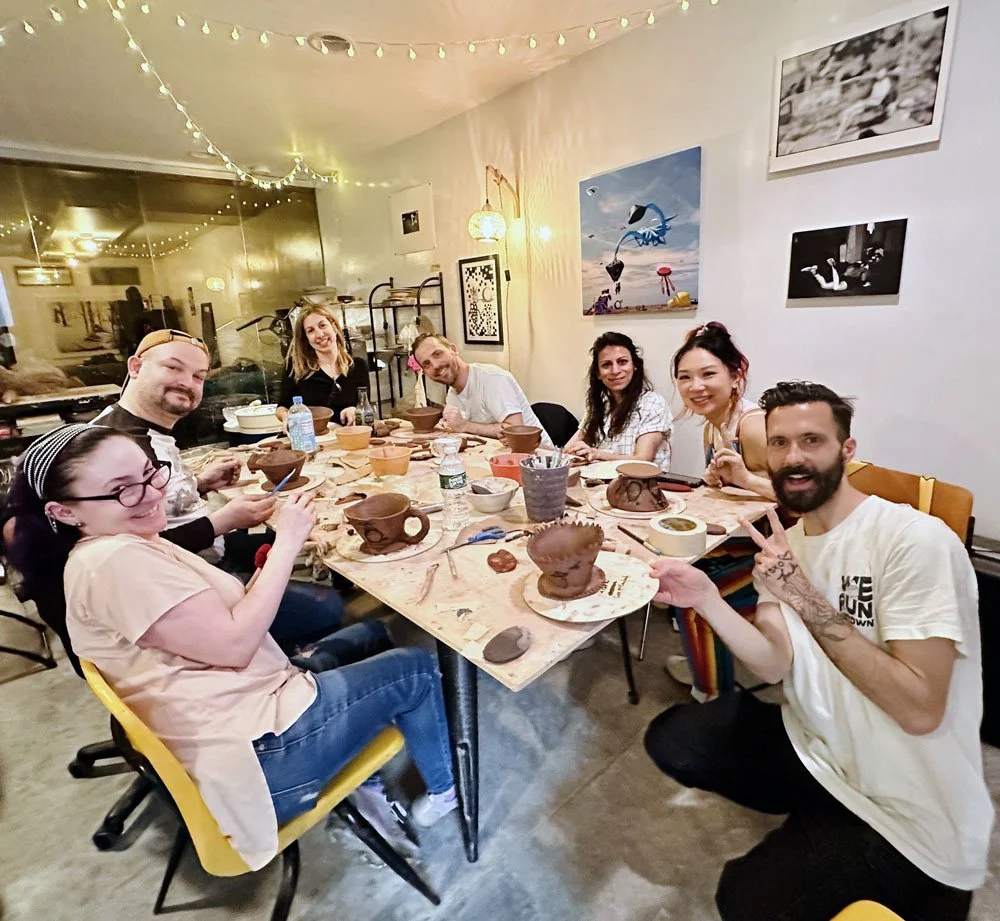A team hand-building clay pieces together at a corporate pottery team-building class at Bat Haus in Brooklyn.