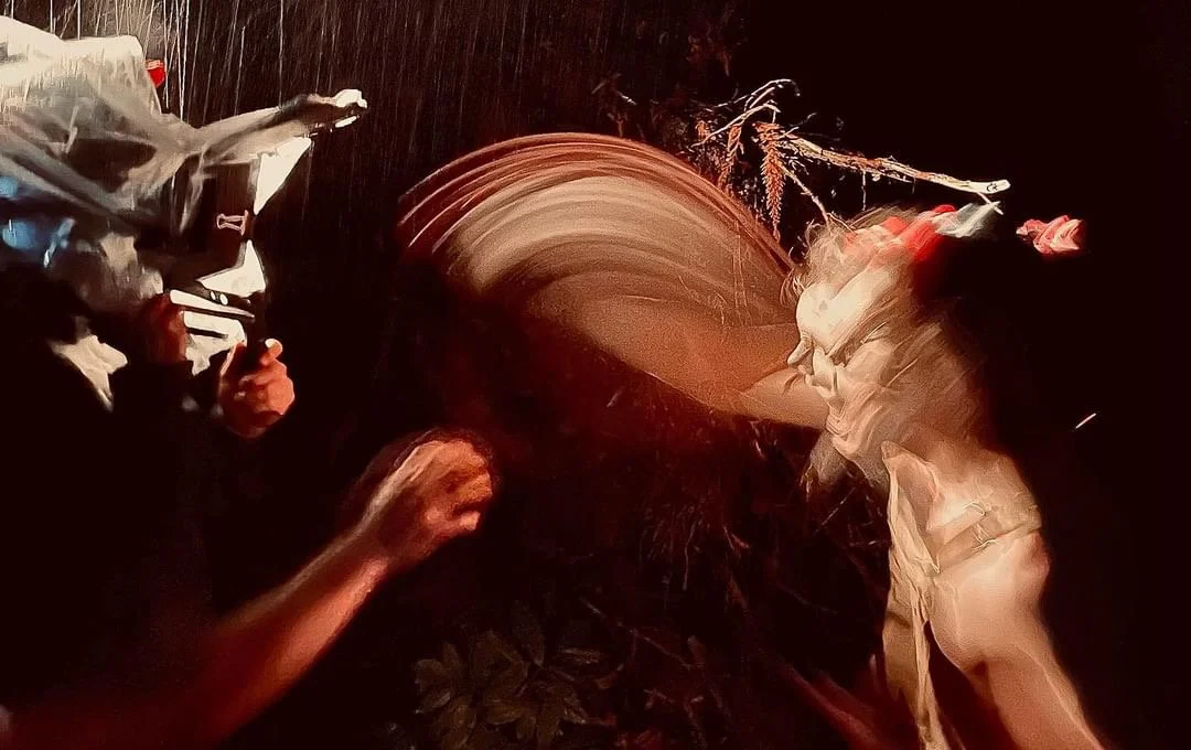 Blurry image with a woman and a man at a party or gathering, indistinct details due to motion blur.