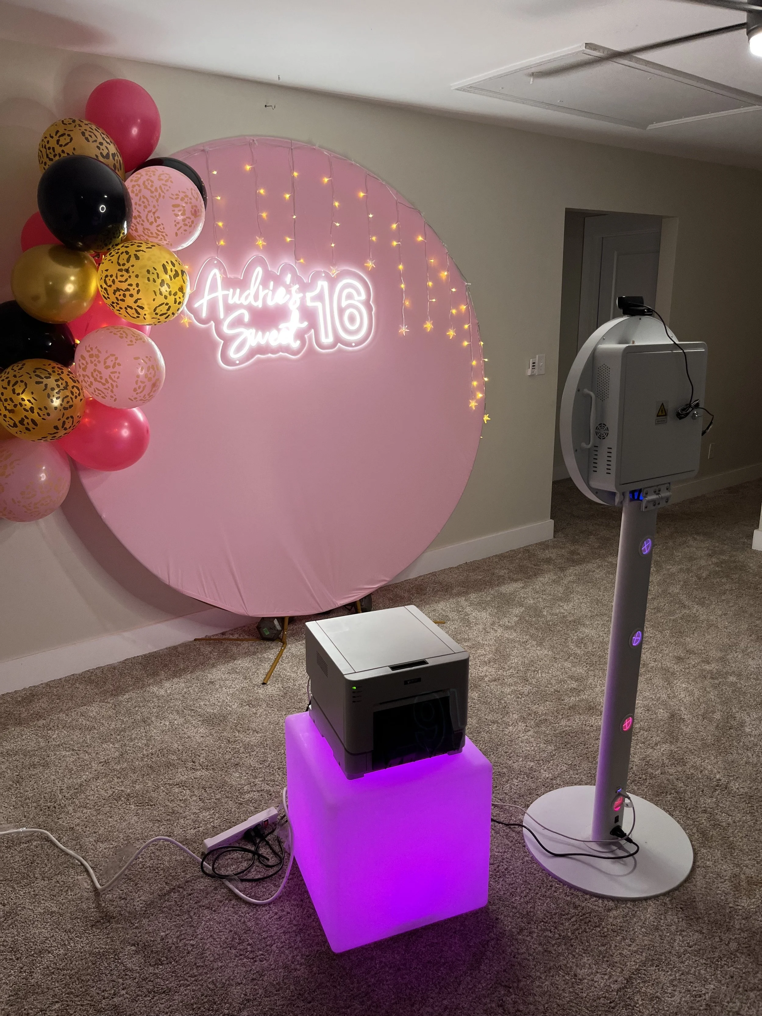 Photo booth setup with Sweet 16-inspired backdrop
