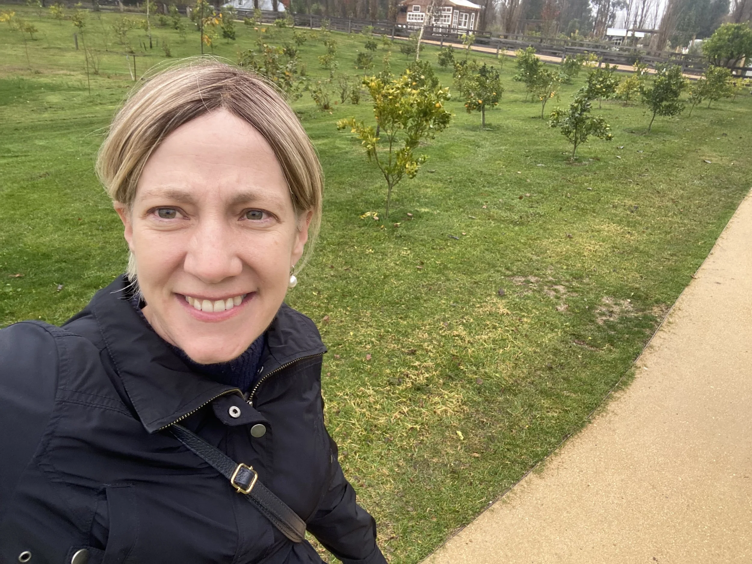 Artist, Jessica Sutherland, smiling outdoors in a park.