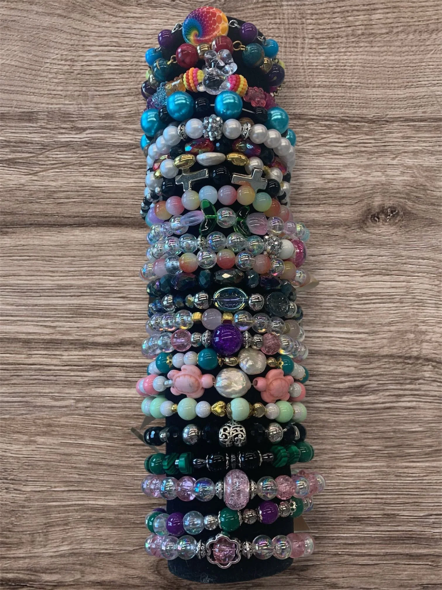 A collection of colorful beaded bracelets arranged in a line on a wooden surface.