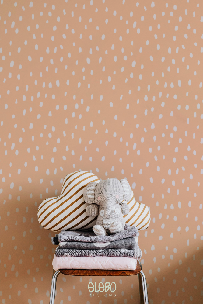 spots-light-peach-and-white-nursery-with-toy-elephant.webp