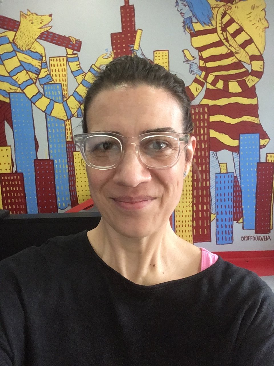 photo of Sophie Madej in front of a colorful abstract mural