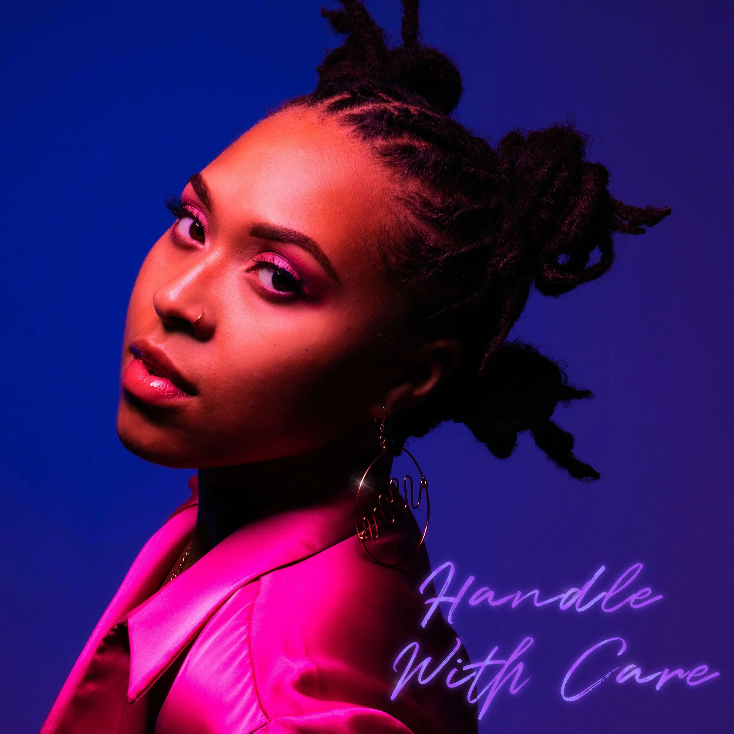 A woman with styled dreadlocks, wearing a pink satin jacket and large earrings, looks at the camera against a blue and purple background. The text 'Handle With Care' appears in purple cursive in the lower right corner. Oliv Blu Handle With Care cover