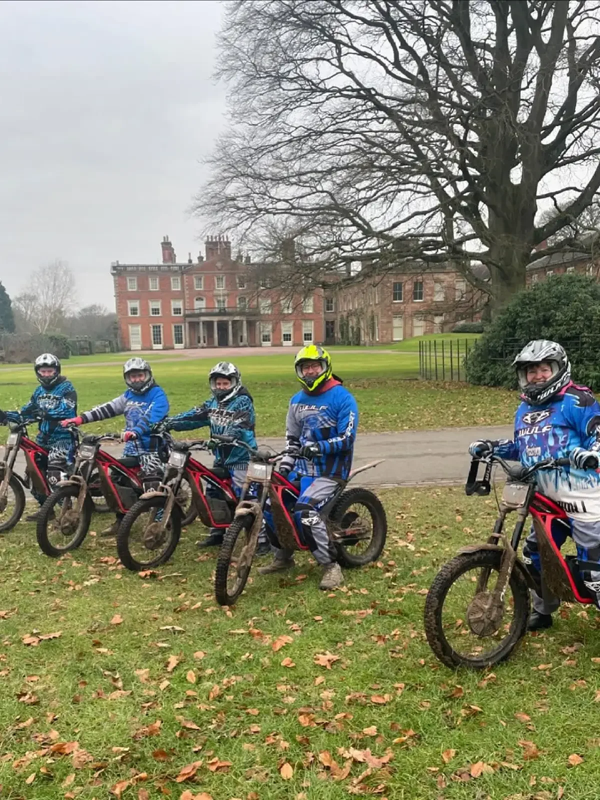 A group of people hiking along a forest trail surrounded by tall trees and lush greenery.