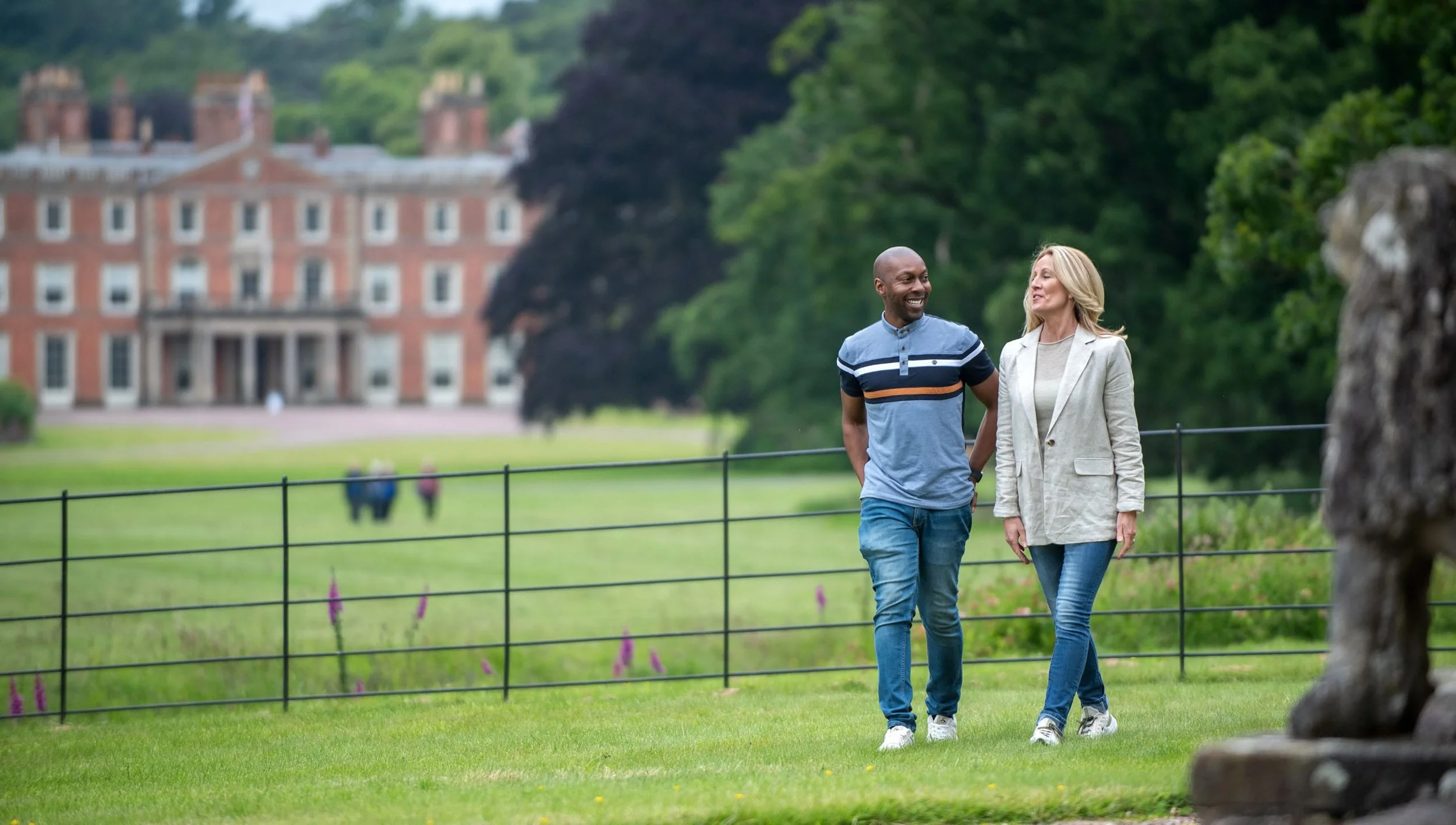 Two people walking outside the house