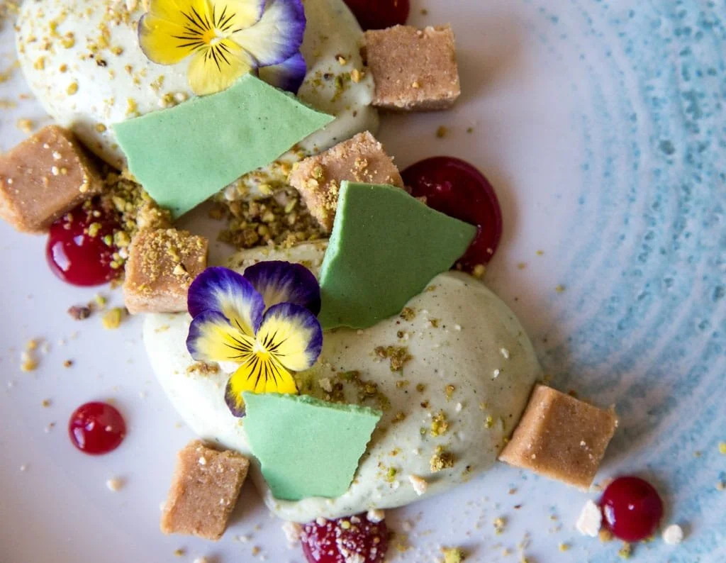 Plate of baked oysters on a white dish with a dark background.