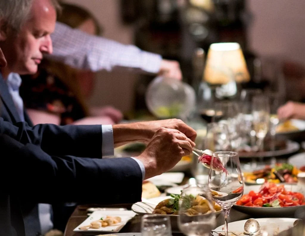 A dessert pizza with holly leaves and orange slices, topped with blue flames and a cup pouring a blue liquid over it.
