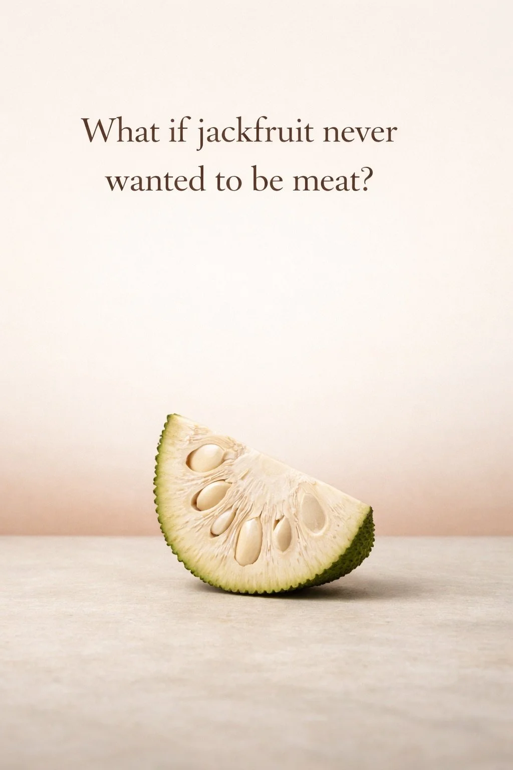 Young green jackfruit wedge on neutral surface beneath the question “What if jackfruit never wanted to be meat?”