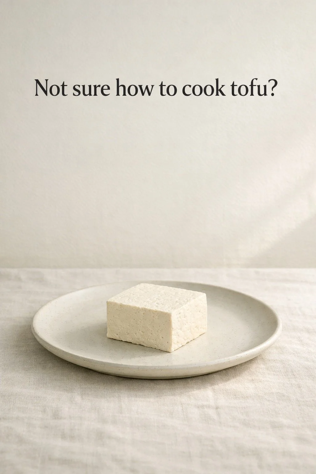 Plain block of tofu on a simple ceramic plate with soft natural light and empty space for a beginner question.