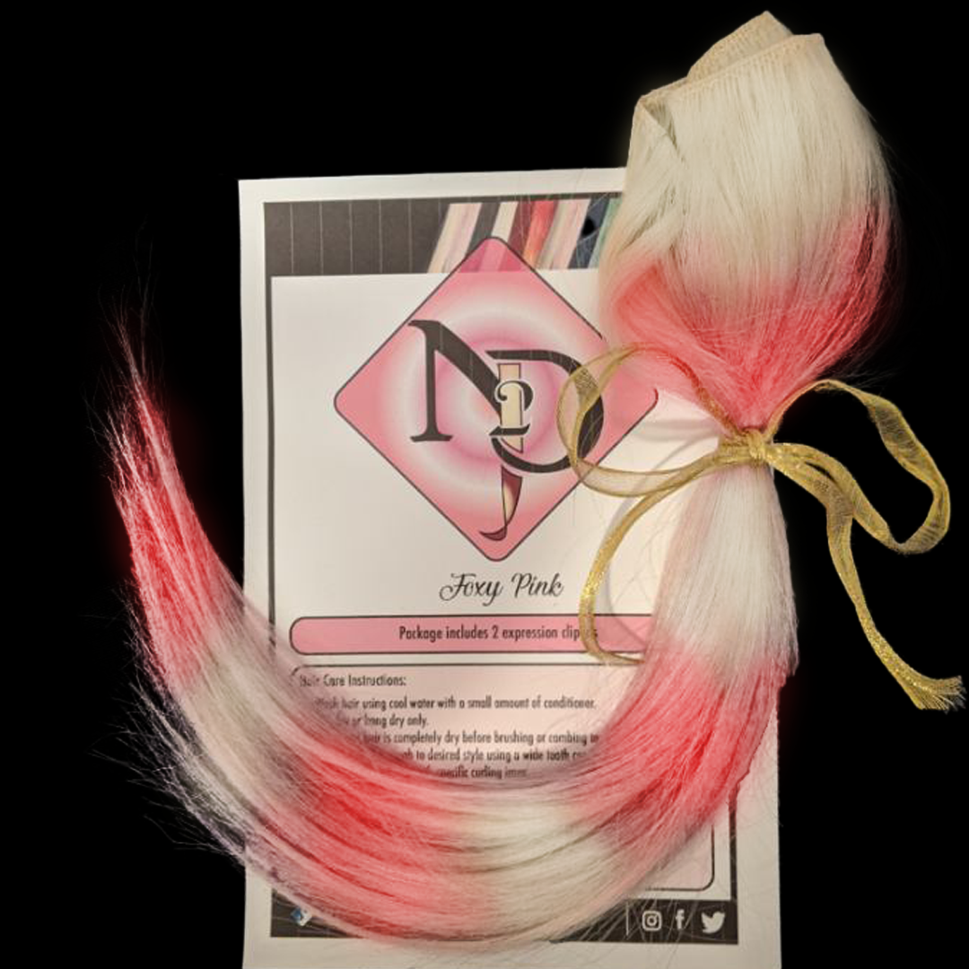 A package of blonde hair extensions with pink tips, tied with a gold ribbon, resting on a color instruction sheet labeled "Foxy Pink".