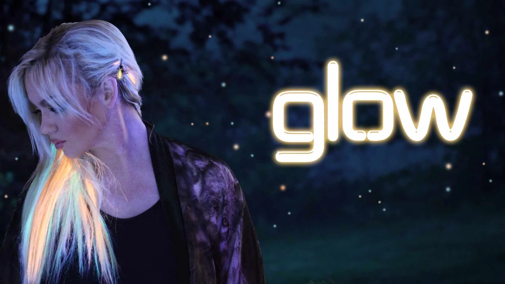 A woman with platinum blonde hair, styled with colorful streaks, looking downward against a dark, starry background. The word 'glow' appears in glowing white neon lights.