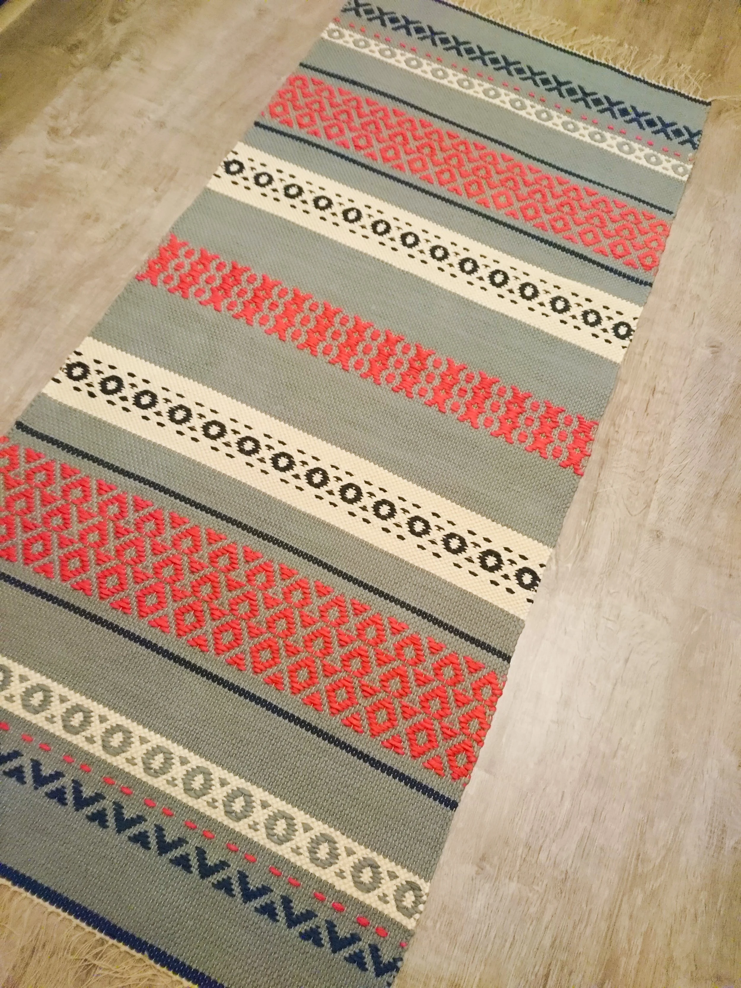 Langat yli äyräiden itsetehty kuvioitu matto.