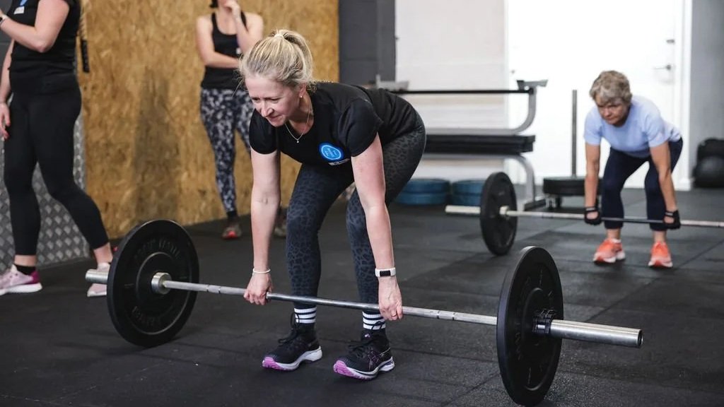 women deadlifting barbells in the gym, women strength training