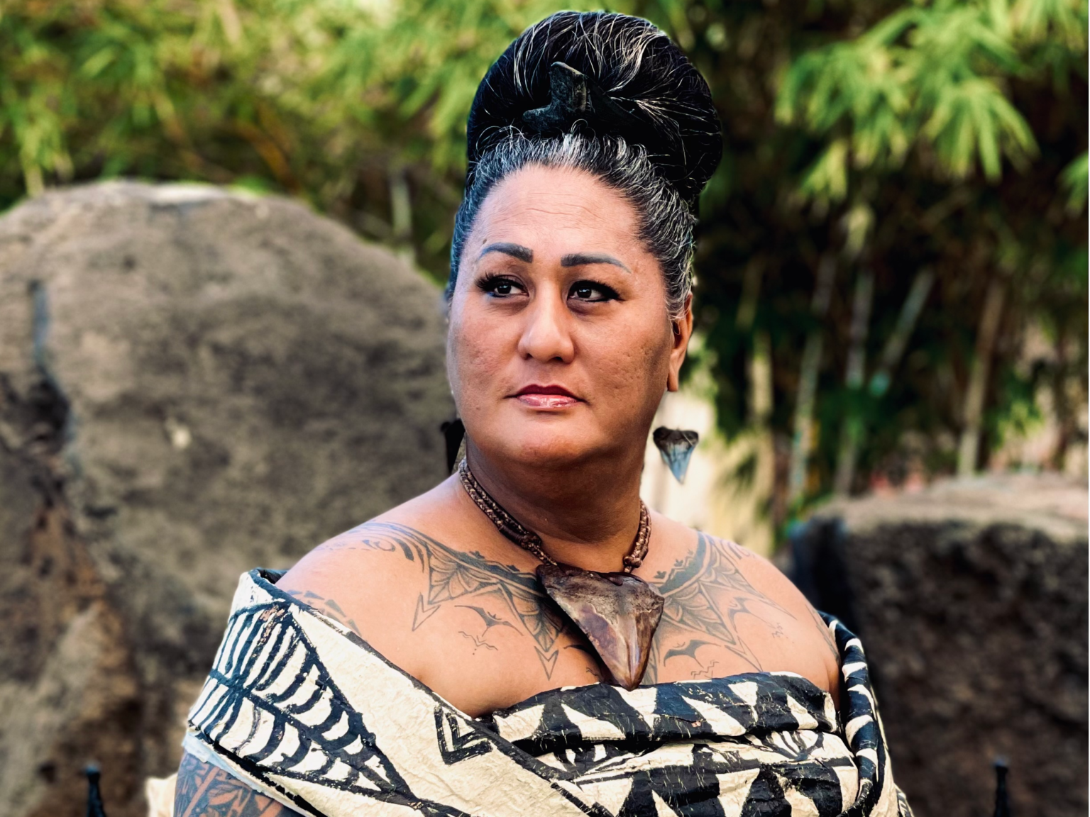 Headshot picture of a Pasifika woman wearing traditional clothing,confidently looking right off into the distance