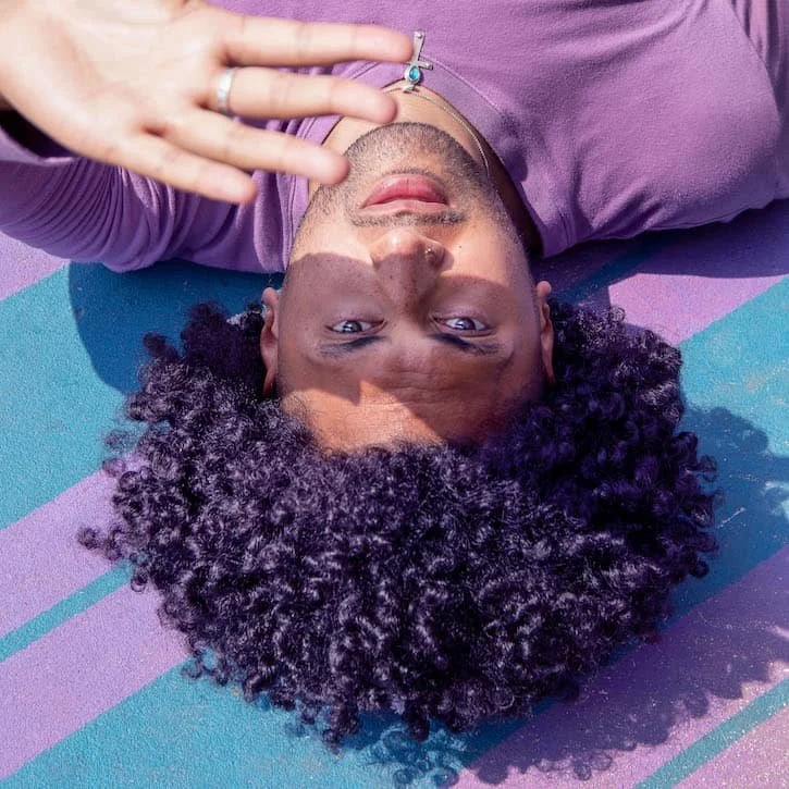 Man laying on the ground looking at the camera