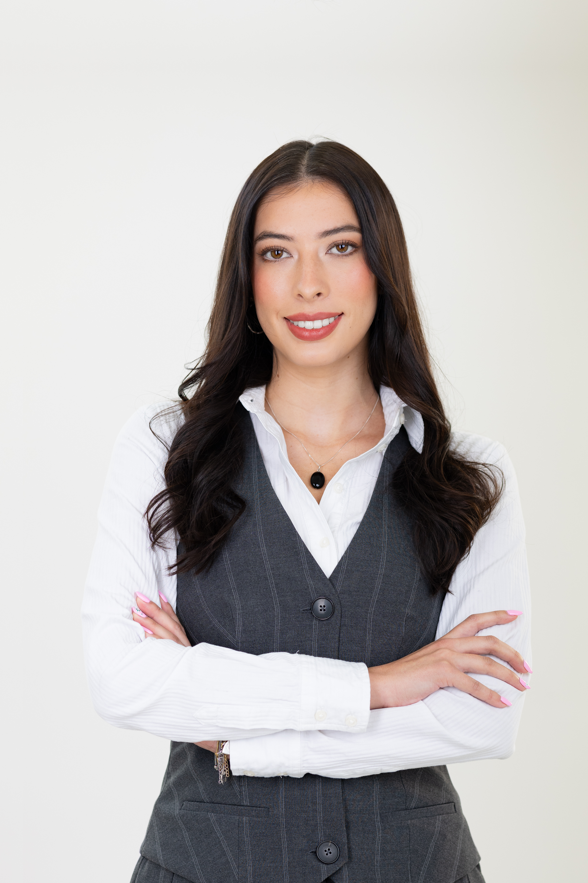 Meet Avary Thorne, HR Operations Specialist at Exclusive Business Concierge. Image of Avary wearing a white shirt and a gray vest, standing with arms crossed against a plain white background.