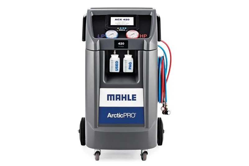 Une machine de diagnostic automobile Mahle ArcticPRO avec deux manomètres, un compartiment pour des liquides de test, et plusieurs tuyaux attachés à droite.