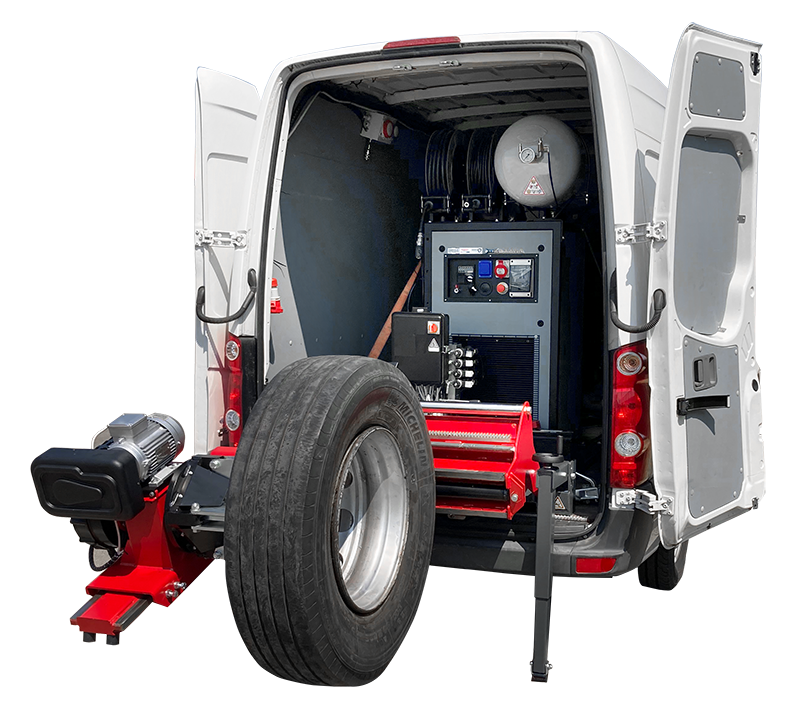 Une caméra mobile de test de pneus fixée à l'arrière d'une petite camionnette blanche, avec un équipement technique à l'intérieur de la camionnette.