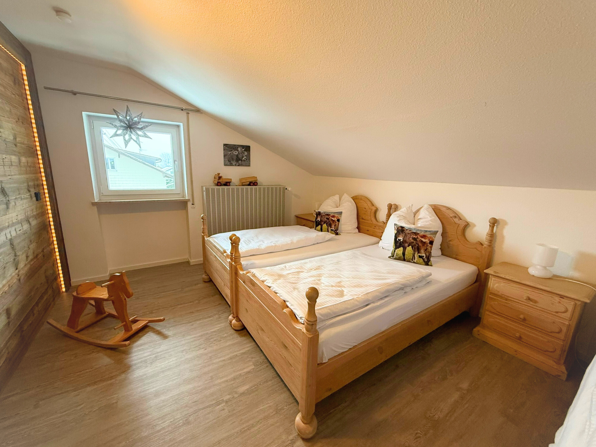 Kinderzimmer mit drei Einzelbetten und dekorativer Altholzwand