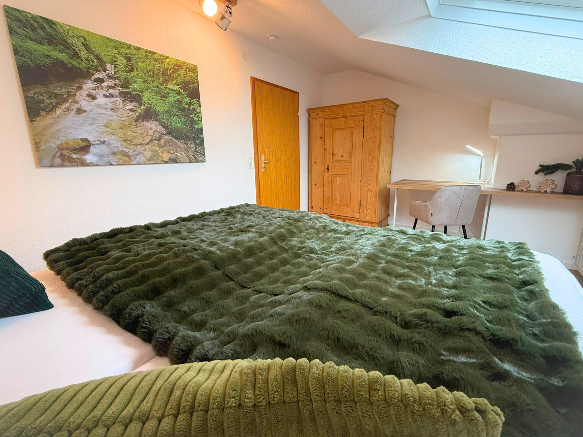 Schlafzimmer mit Doppelbett (200 × 200 cm) aus Vollholz und einer Workation Station, einem laptopfreundlichen Arbeitsplatz