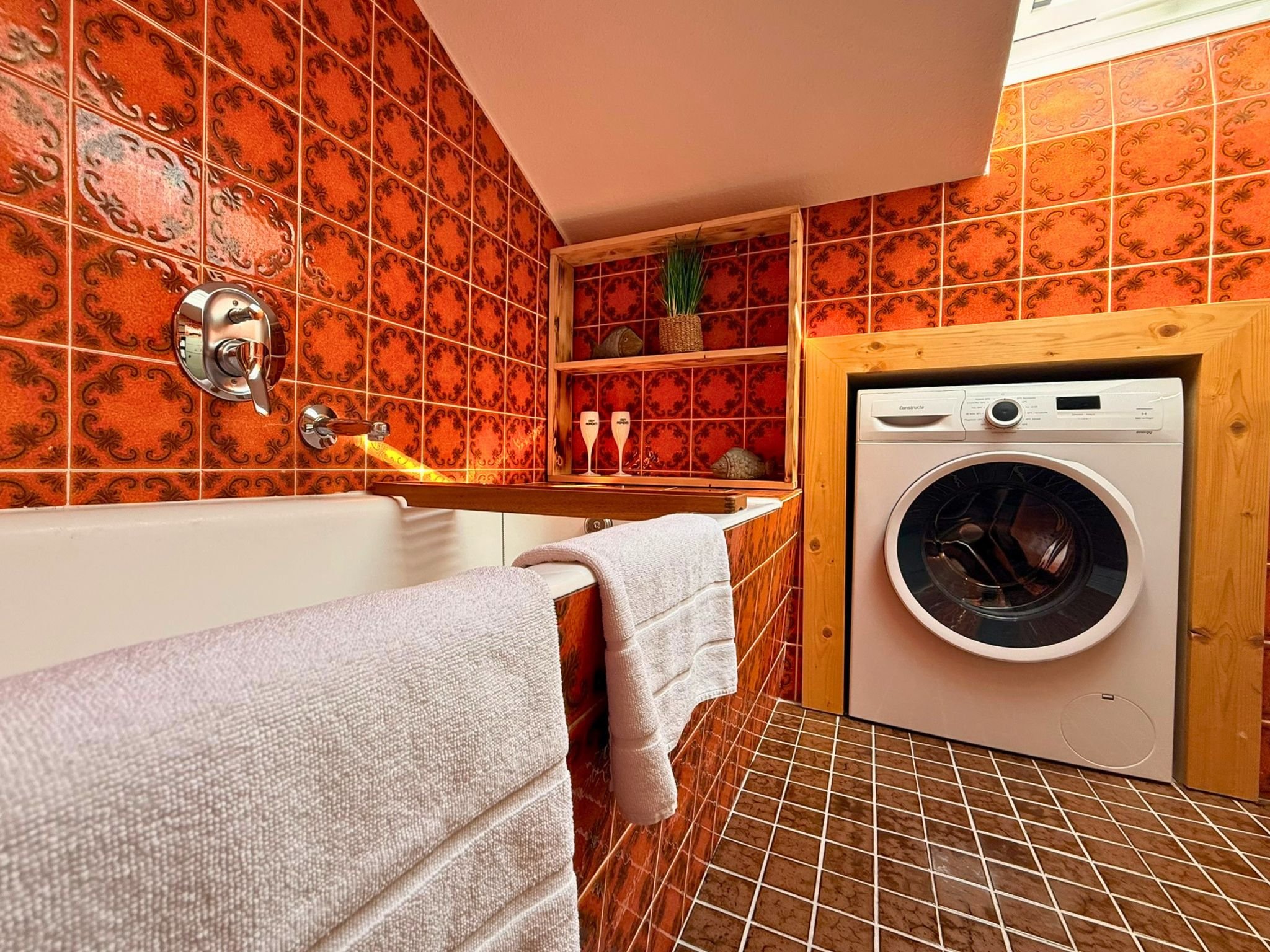 Badezimmer mit Badewanne und Waschmaschine