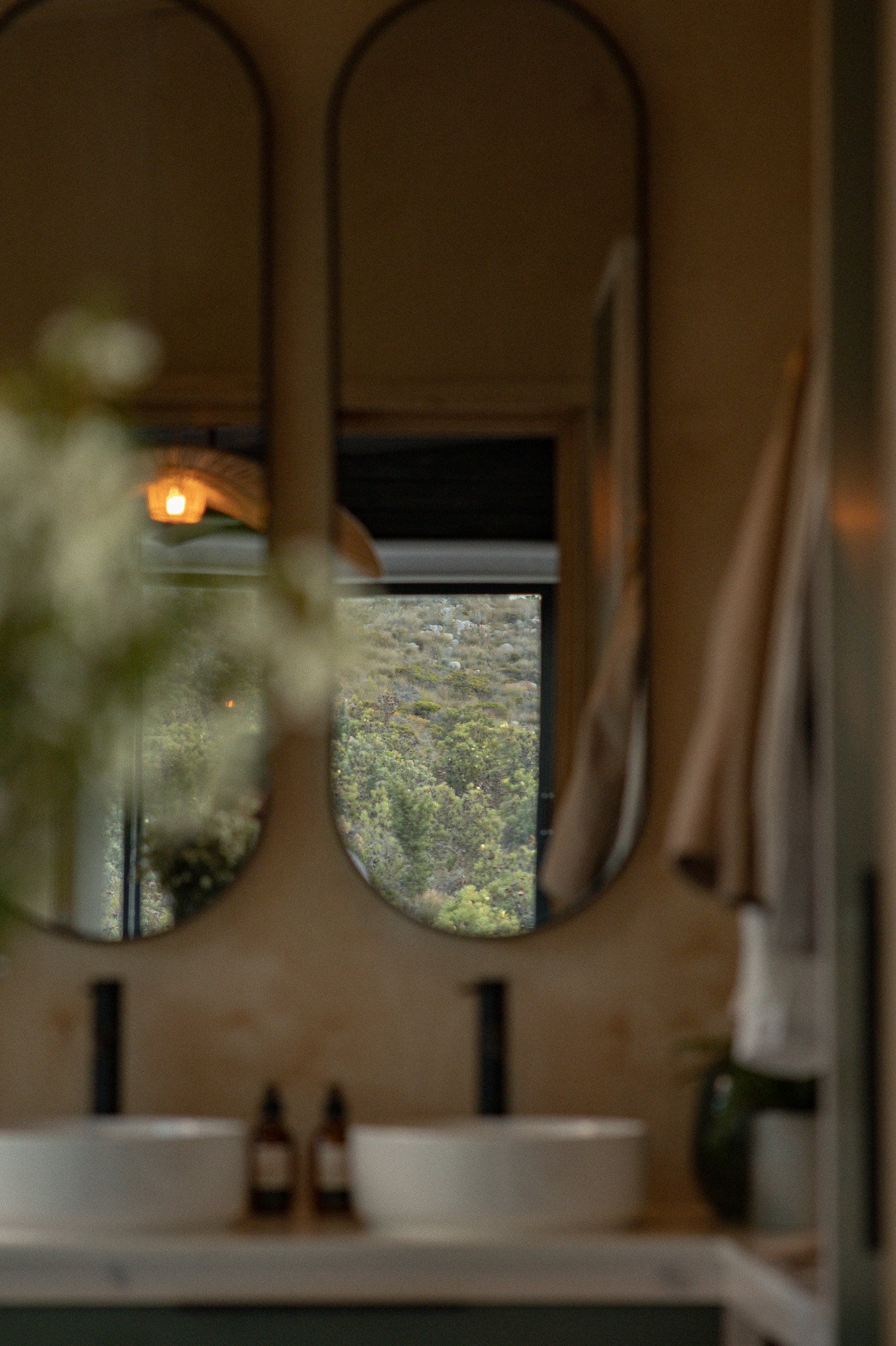 View of mountains and trees through a cutout in a wooden structure, possibly a window or wall.