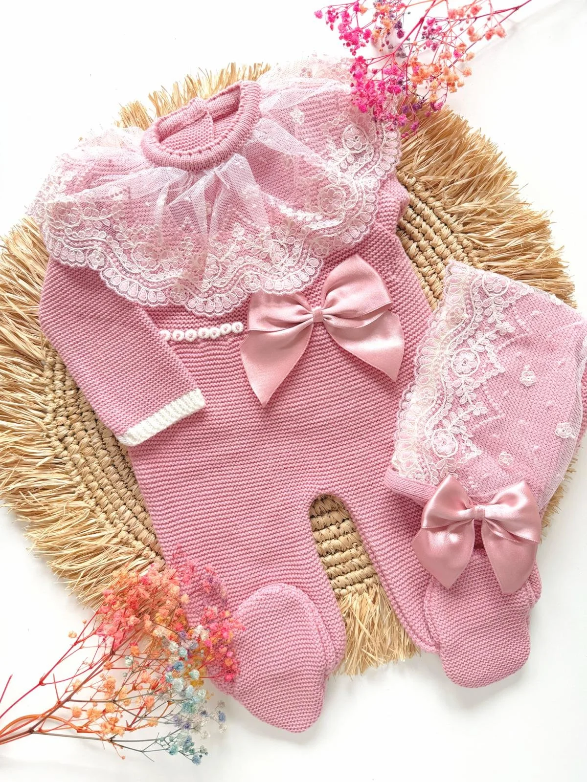 Deluxe Hand-Knitted Newborn Romper Set, includes bonnet, in dusty pink with bow detail. Perfect as a coming home outfit.