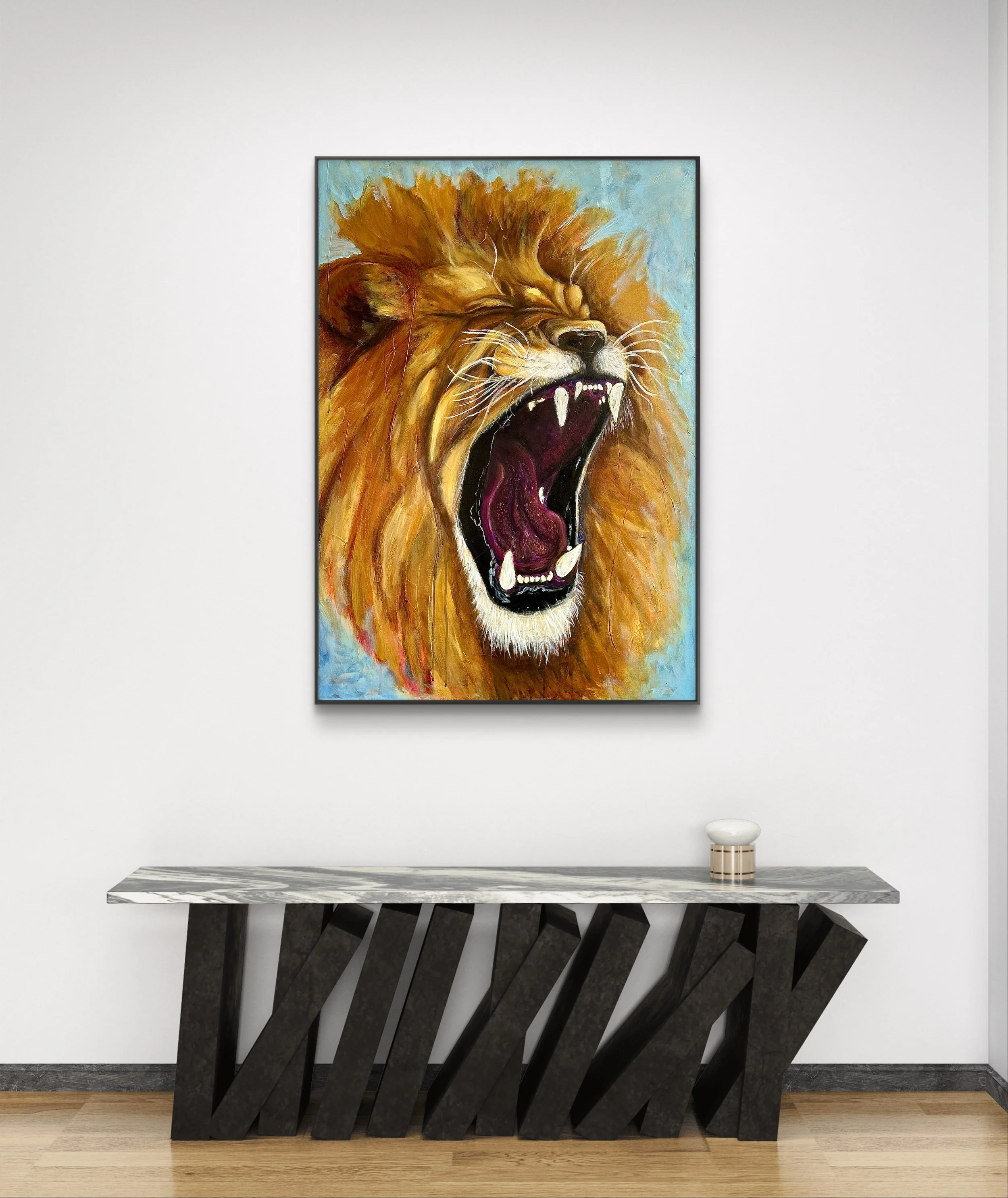 Painting of a roaring lion with a yellow mane on a white wall, above a modern black and white marble and wooden console table.