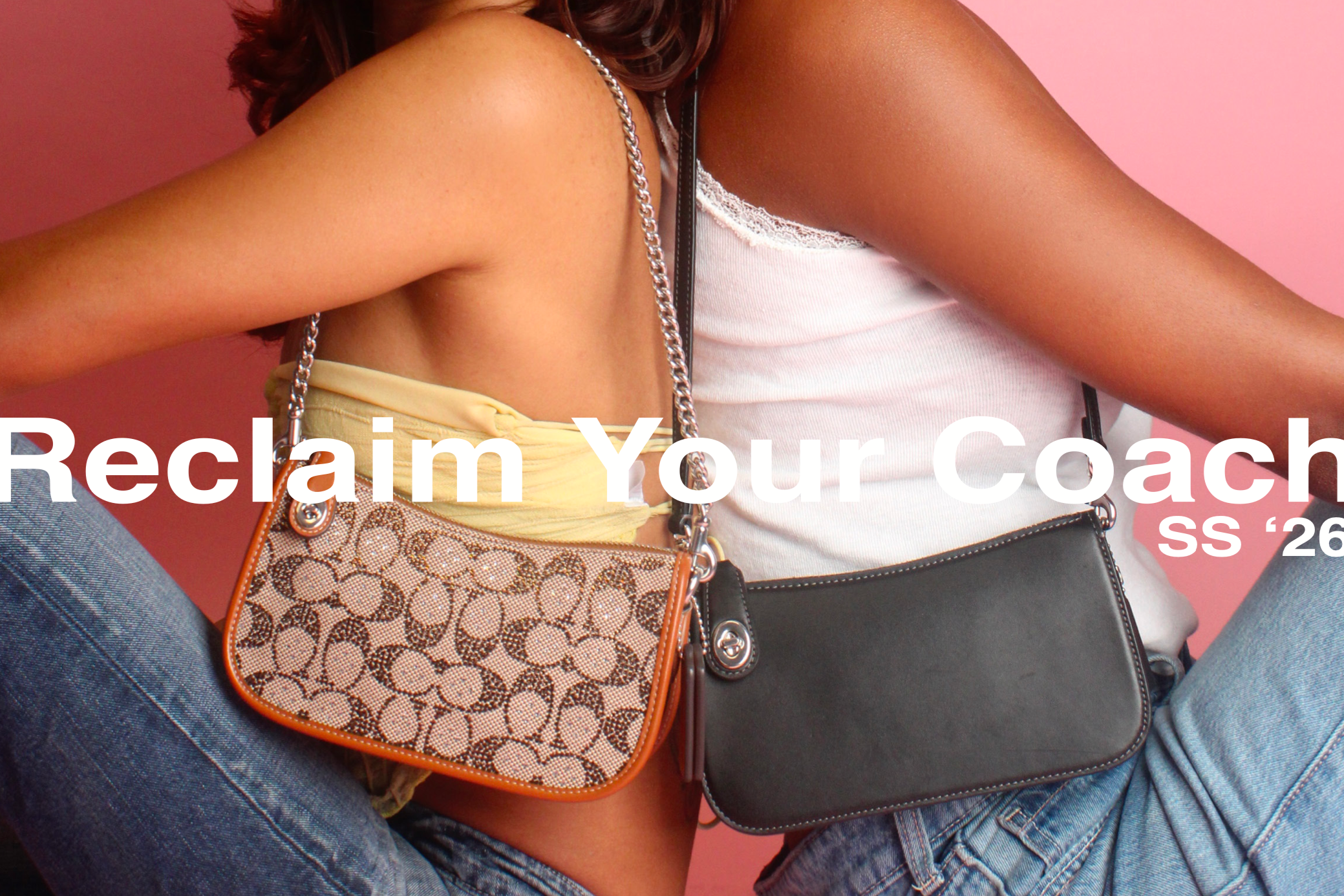 Two women sitting close together with their arms around each other, wearing casual tops and jeans, each carrying a handbag, against a pink background.