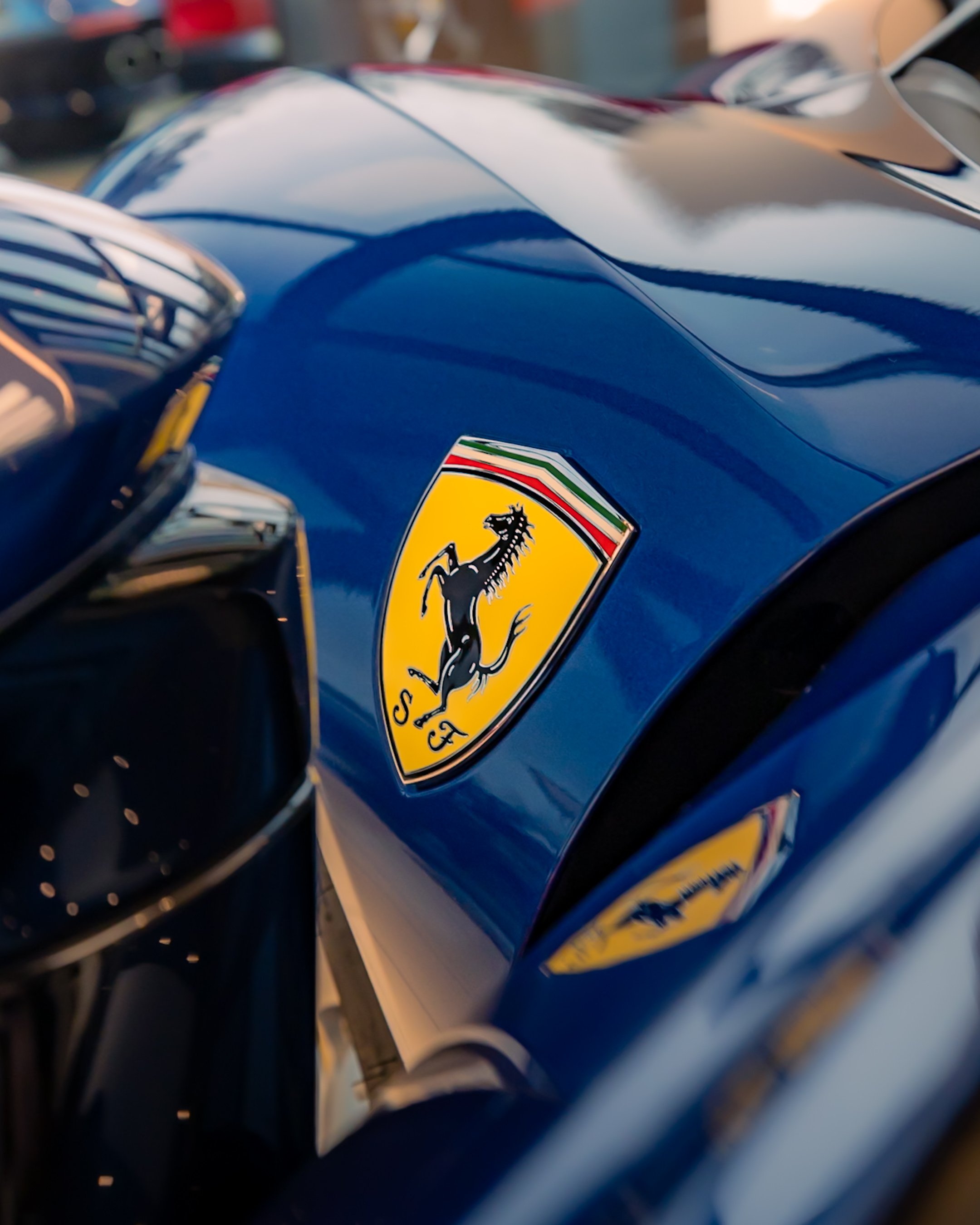Close-up of Ferrari logo on blue car