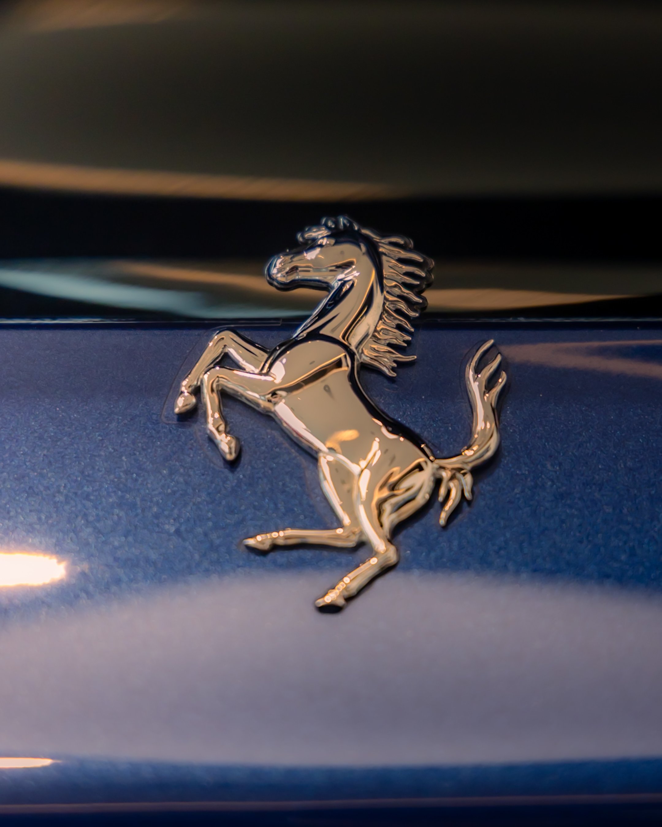 Ferrari prancing horse emblem on blue car